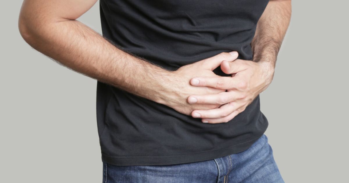 Man holds stomach in pain