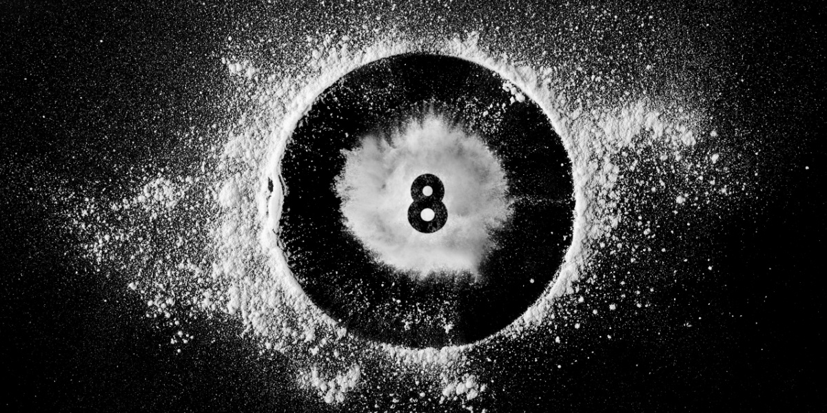 Black eight ball partly covered by a burst of white powder.