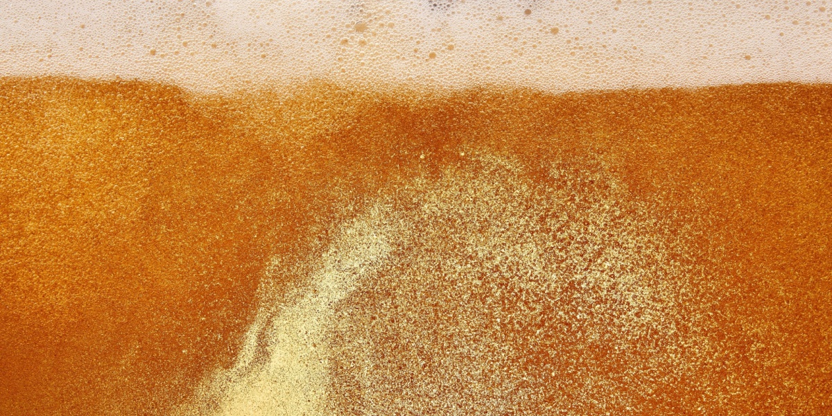 Close up picture of amber beer foaming in a glass
