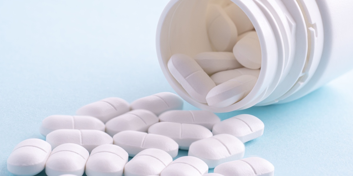 a close up photo of a pill bottle and several white M367 pills