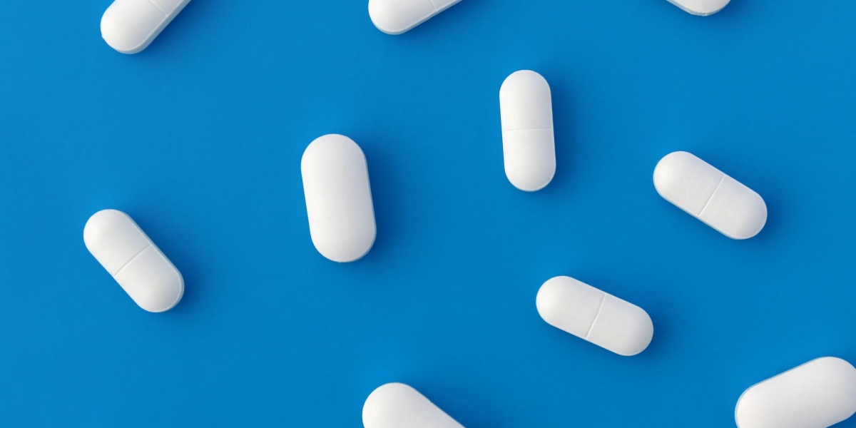 A photo of multiple scattered white oblong IP 109 pills with a blue background
