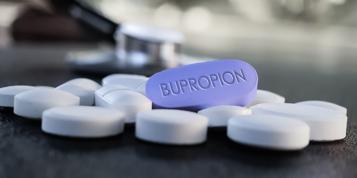 a close-up photo of oblong pills with one of the pills labelled bupropion