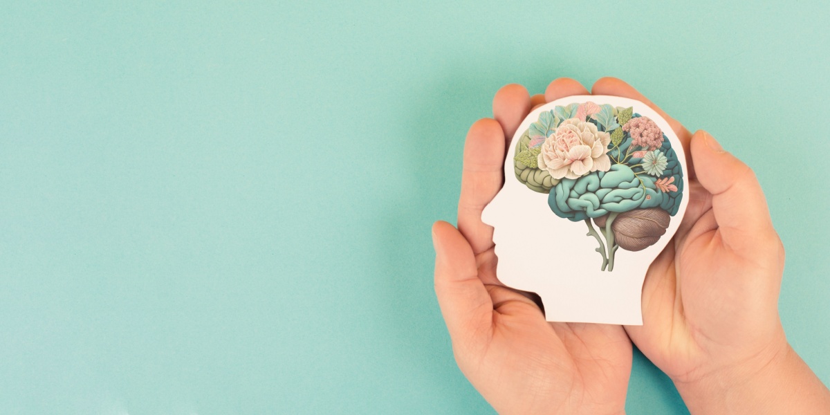 a photo of a hand gently holding a flowery photo of a brain that seems to be healing or recovering