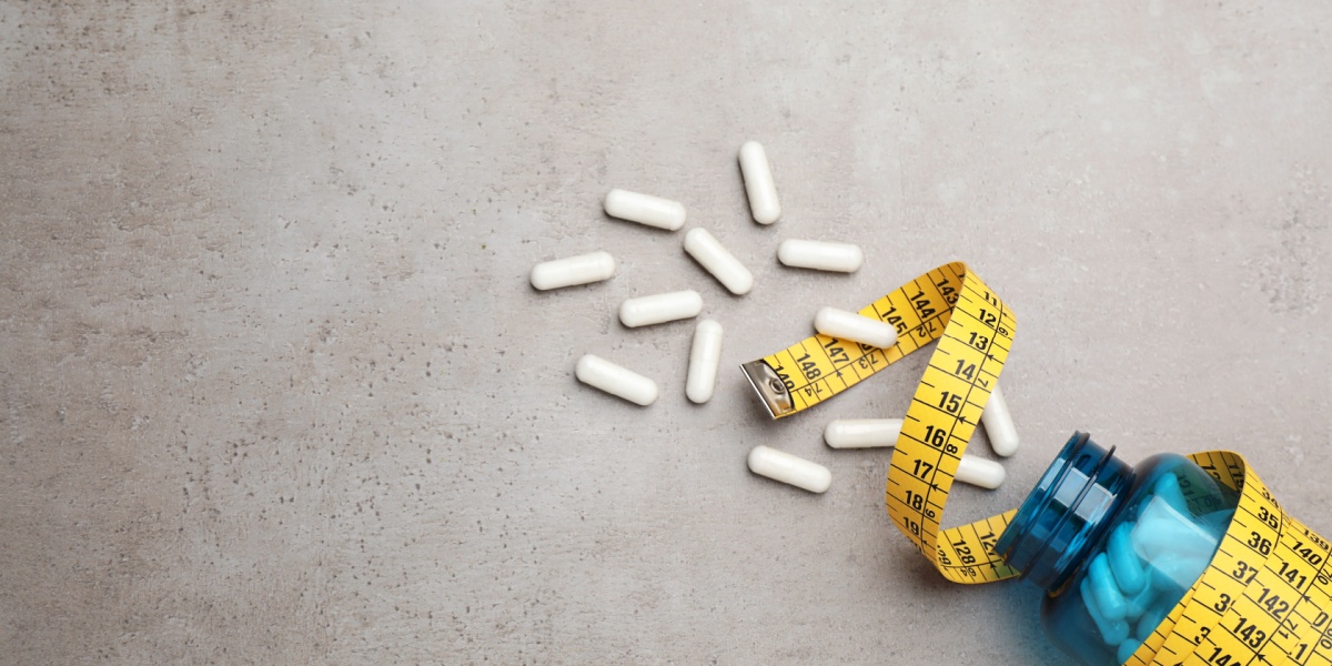 a photo of a spilled Adderall pill bottle with a tape measure wrapped around it