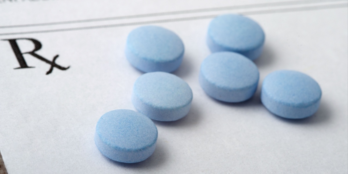a photo of blue Adderall pills on top of a prescription note