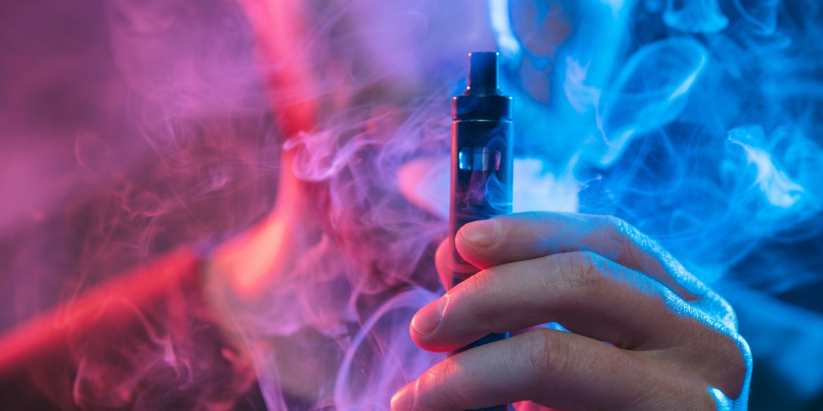 a close up photo of a hand holding up a THC vape pen
