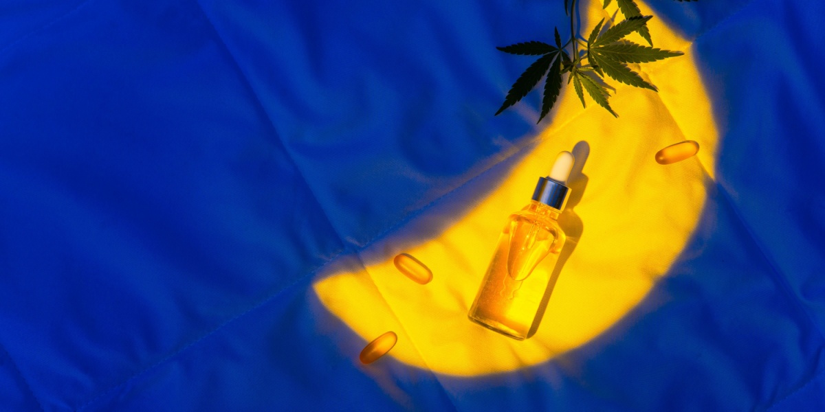 a photo of marijuana products spotlighted by a moon-shaped yellow light over a dark blue background