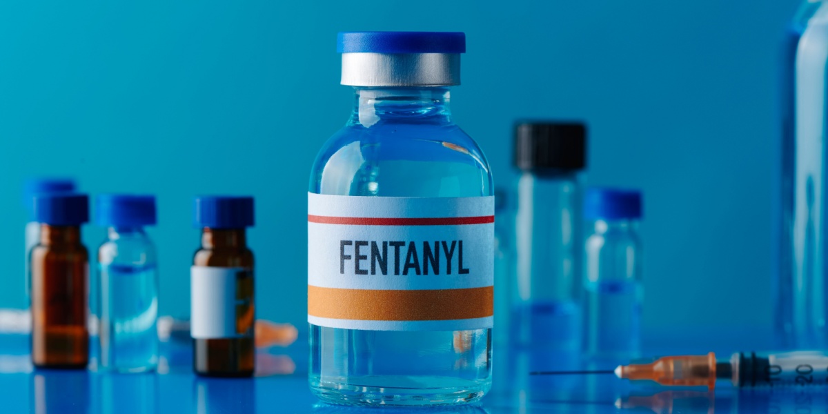 a photo of a bottle of fentanyl in the middle of bottles of different substances
