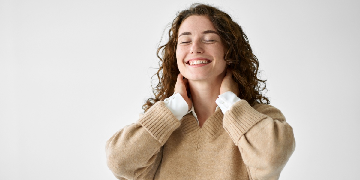 a photo of a Caucasian woman with curly hair enjoying being pain-free after ketamine treatment