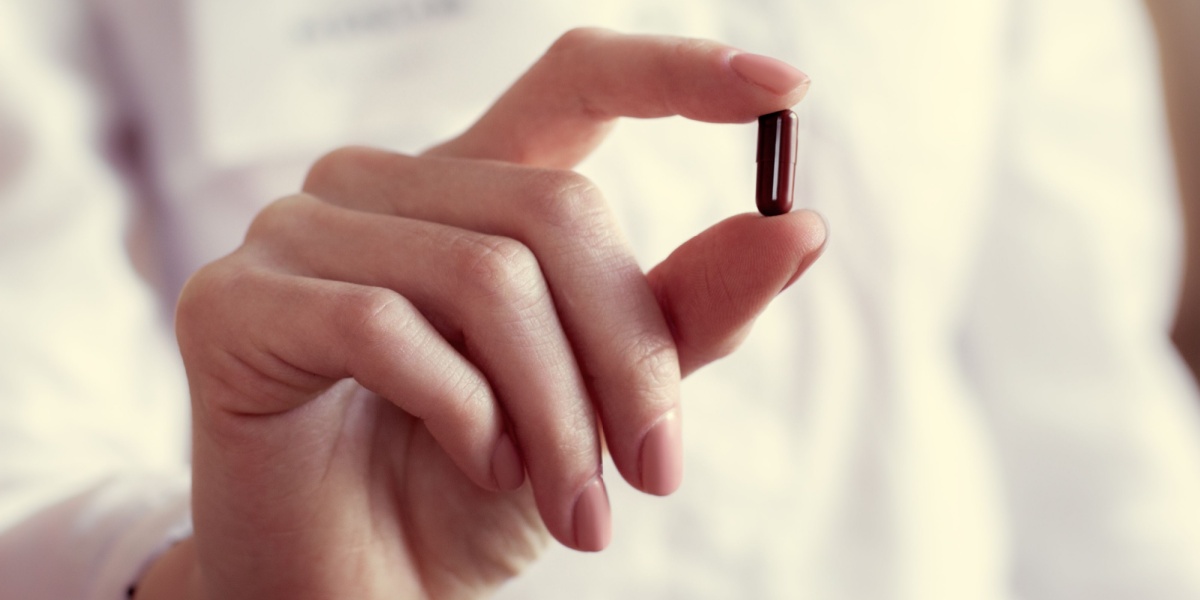 a close up photo of a woman's hand holding an Effexor capsule 
