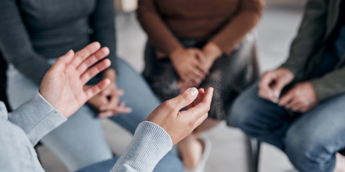 a close up photo of a Sex Addicts Anonymous (SAA) meeting with people gathered in a small circle