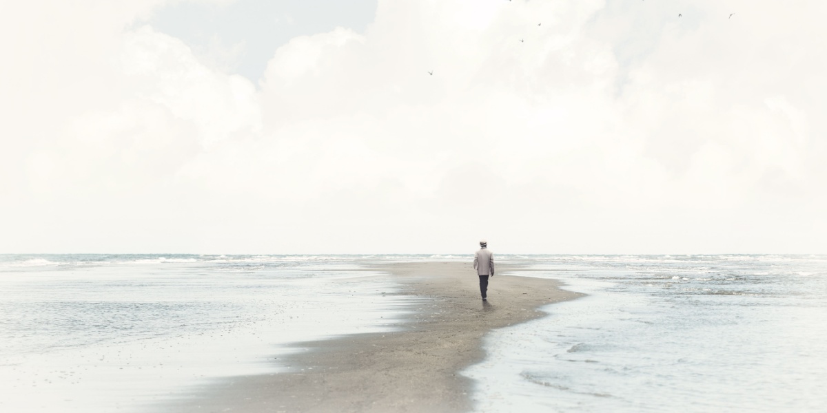 a wide shot of a man walking alone on a path