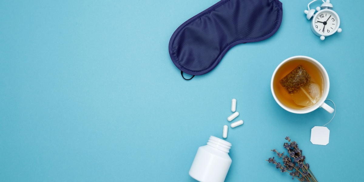 a top view photo of different sleep medications, concoctions, and accessories spread out over a teal background