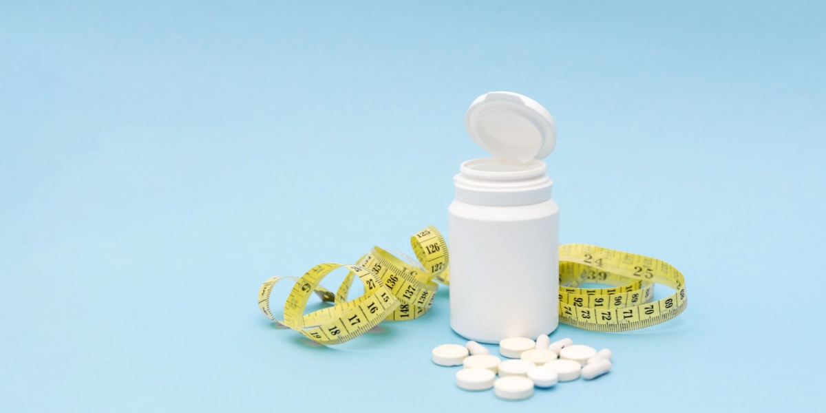 A photo of a prednisone bottle, pills, and a tape measure over a light blue background.
