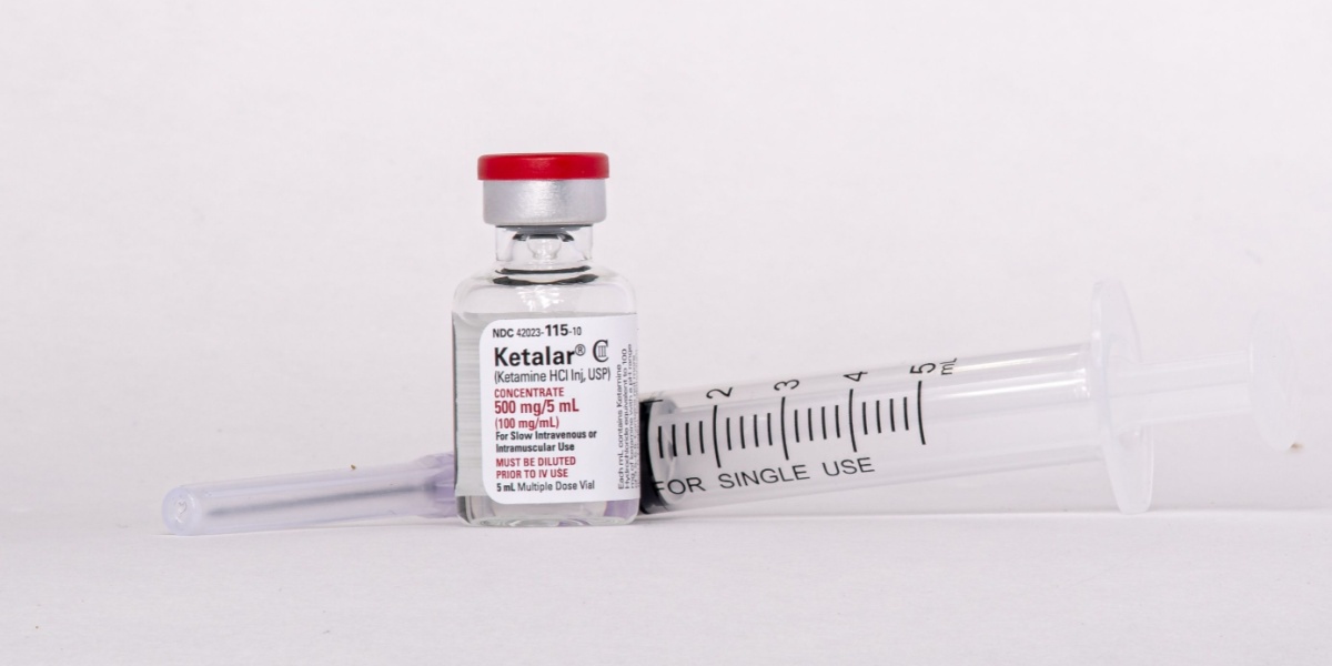 vial containing liquid ketamine and a syringe
