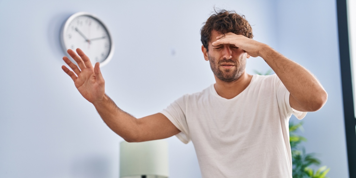 A photo of a caucasian man in white shirt who seems to be feeling dizzy due to quetiapine withdrawal