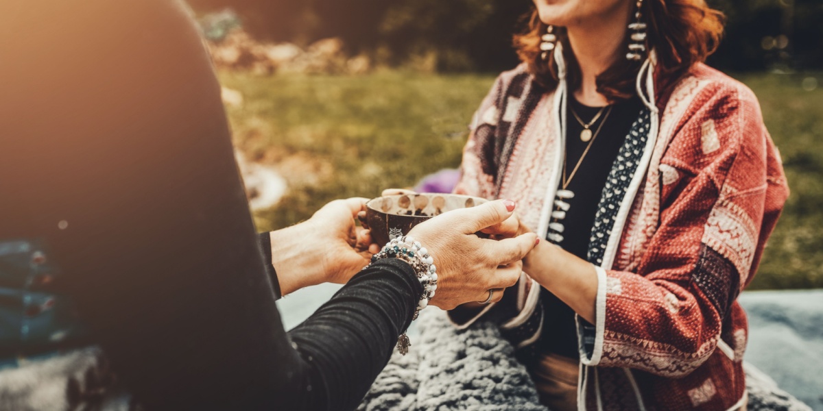 A close up photo of unidentified women holding hands during a psychedelic retreat.