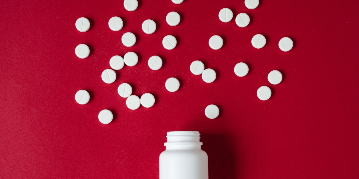 A photo of a desoxyn pill pottle and pills scattered over a vibrant red background