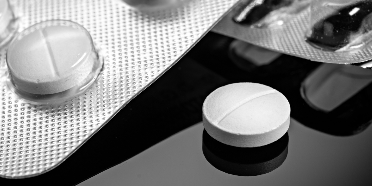 a close up photo of a white methocarbamol pill and the corner of a methocarbamol blister pack