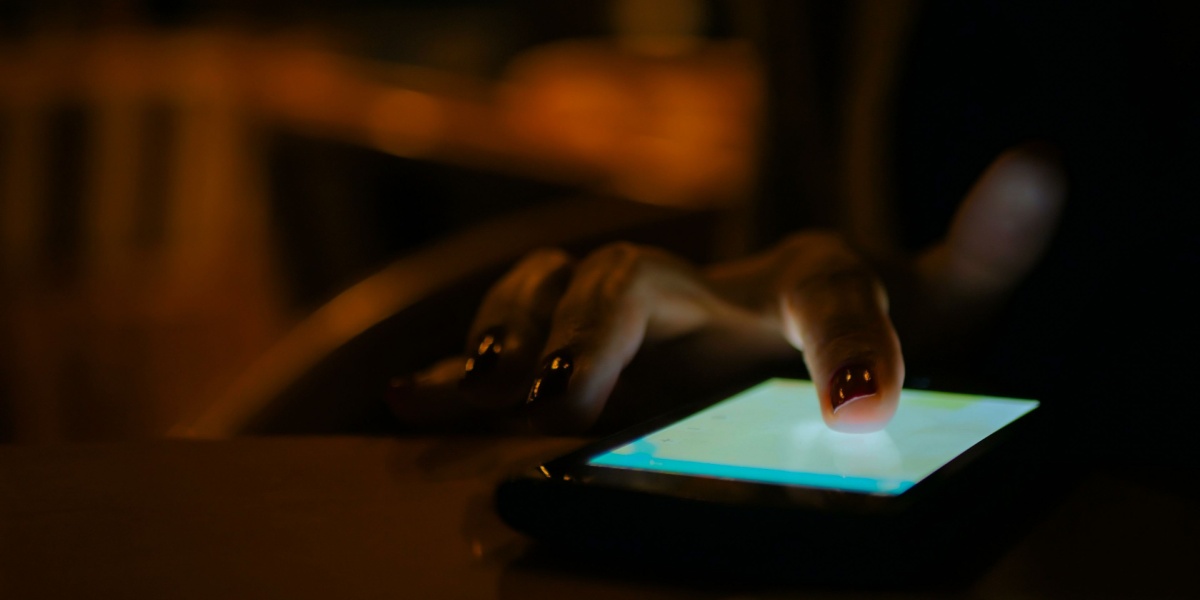 A close up off a hand calling Never Use Hotline on her phone